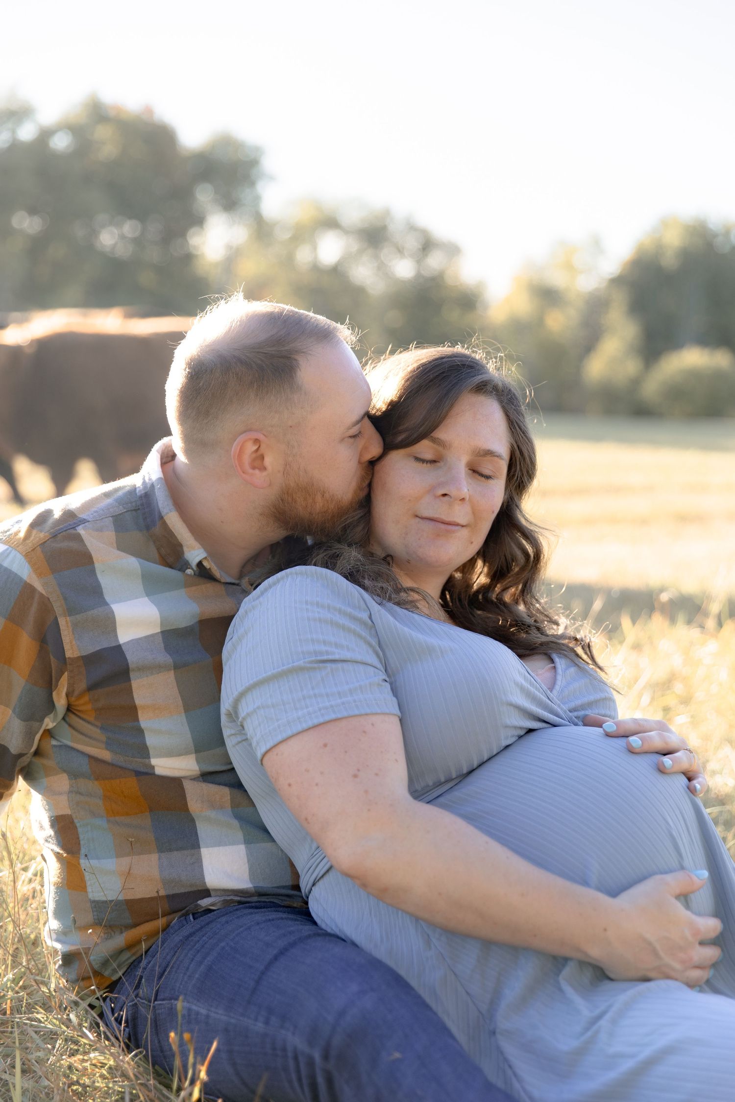 A couple embraces lovingly in a sunlit field during golden hour, captured in a series of intimate moments.