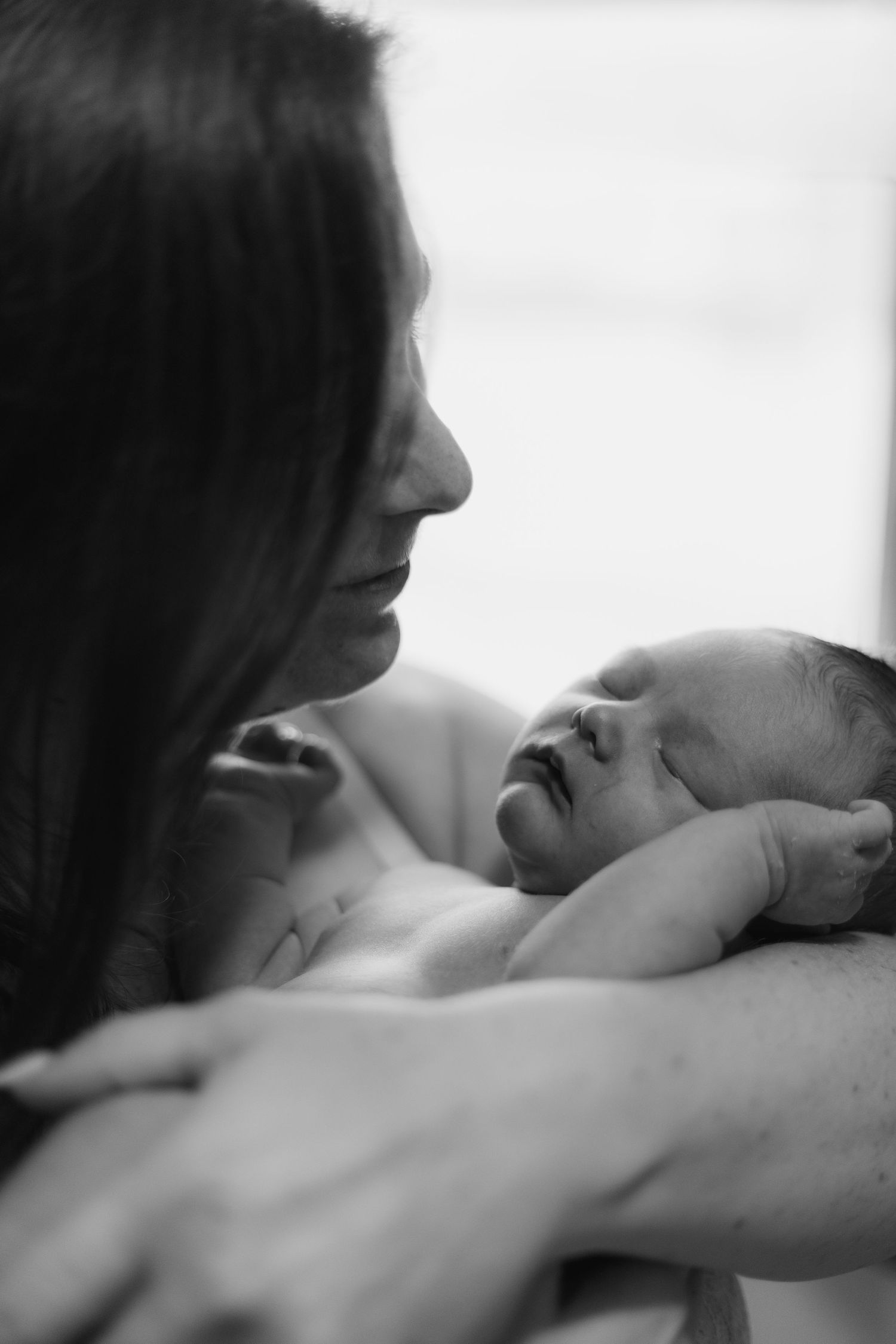 Intimate black and white photo series showing tender moments between a couple in bed.