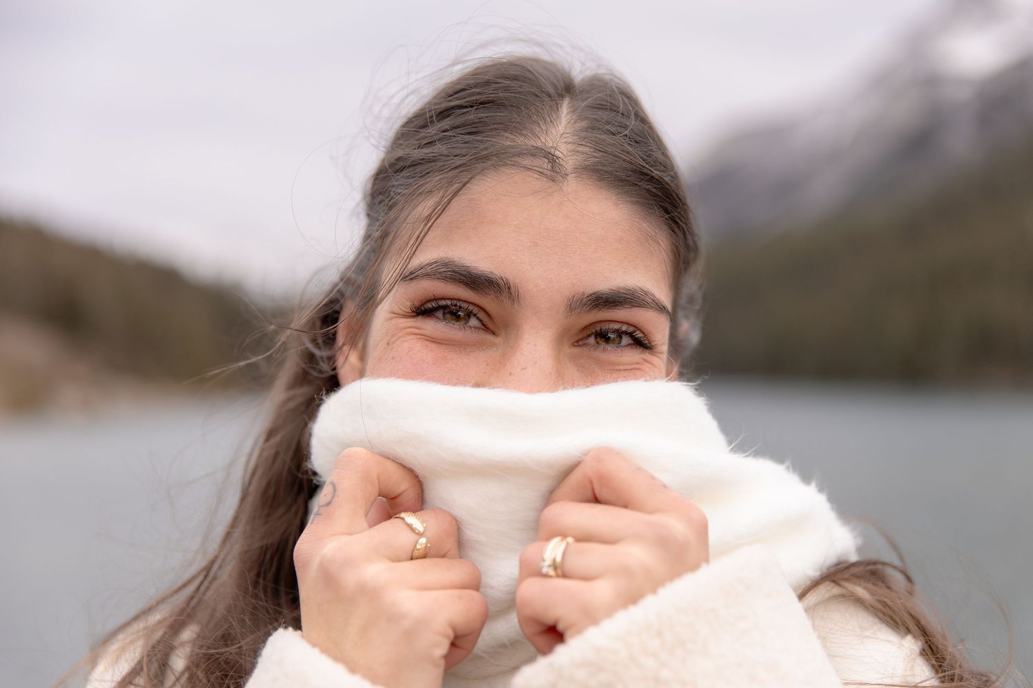 A series of seven cropped photos showing someone holding white tissues up to their face while smiling outdoors.