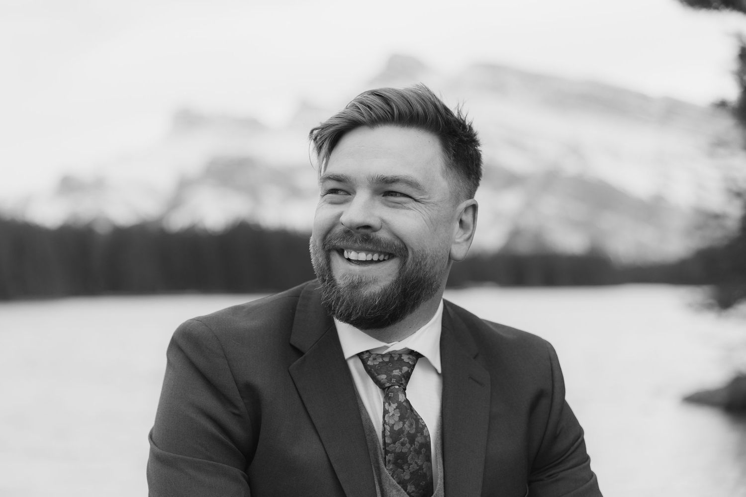 Black and white collage of candid portraits showing joyful expressions and genuine laughter during an event.