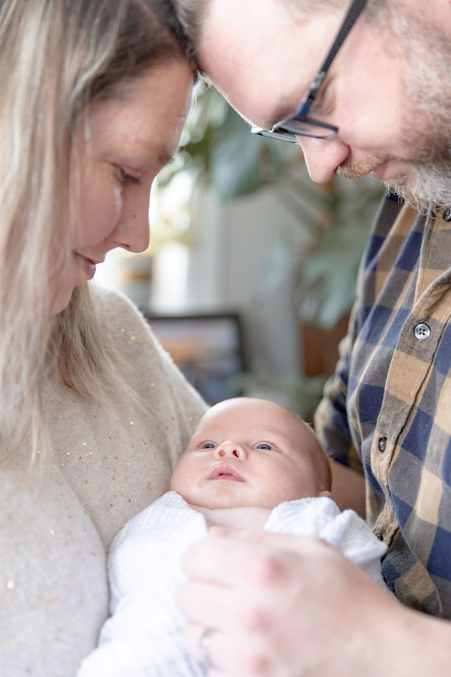 A series of tender moments between parent and baby in a bright indoor setting.