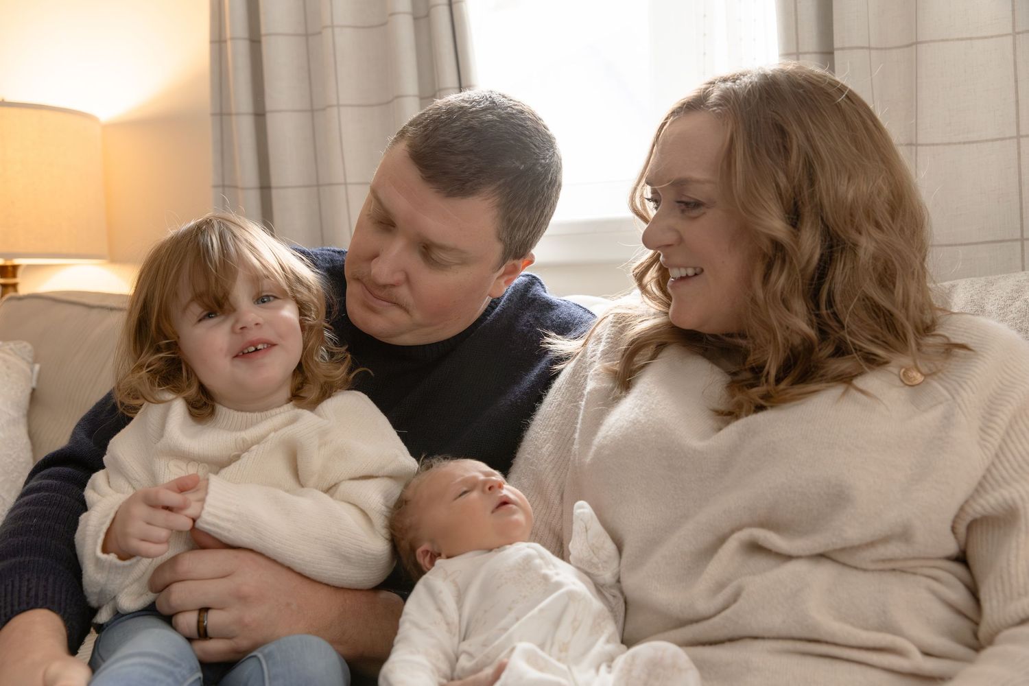 A series of candid family moments showing parents and children sharing tender embraces and laughter on a couch.