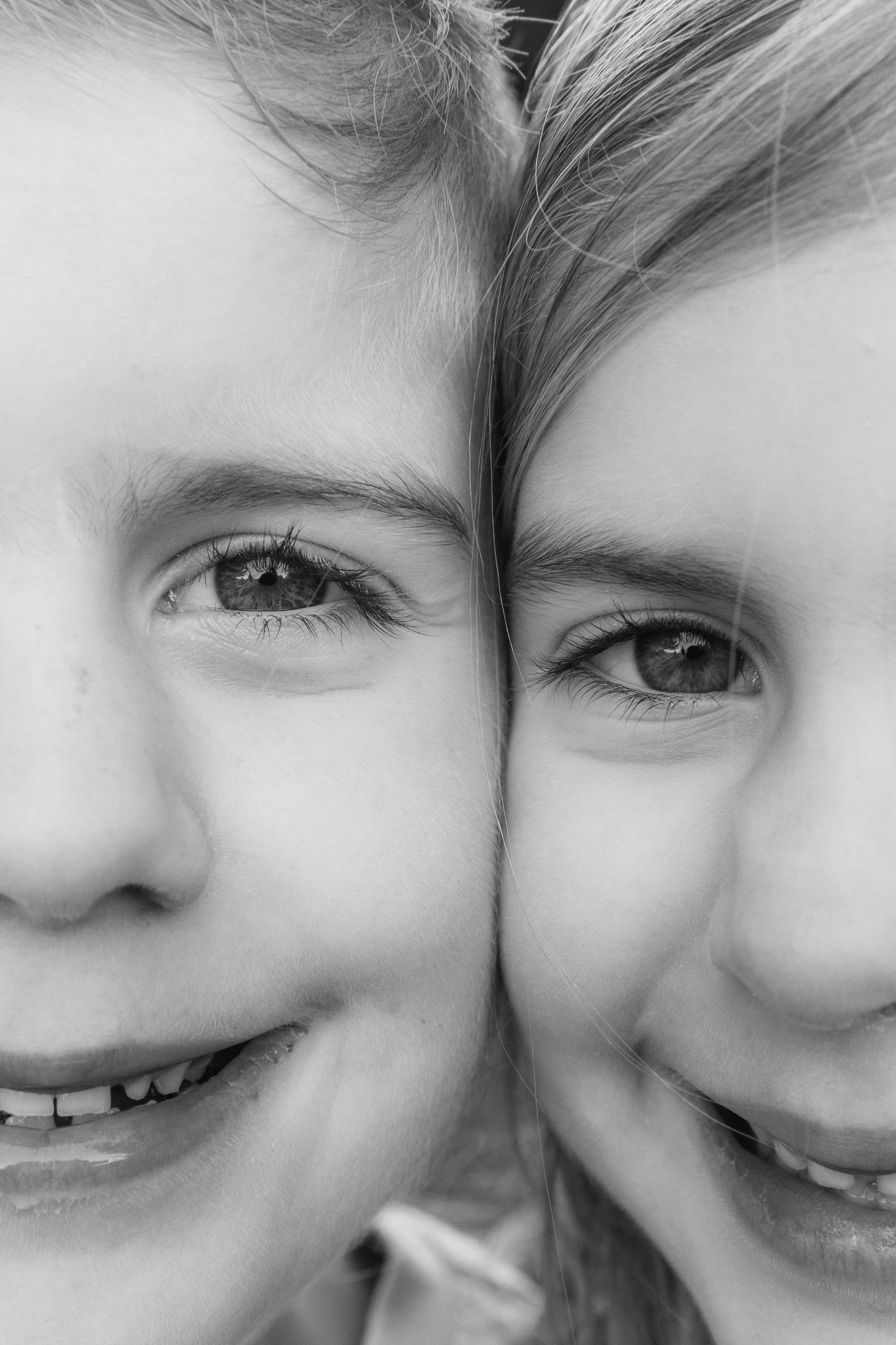 Close-up black and white image showing two smiling expressions in an extreme macro view.
