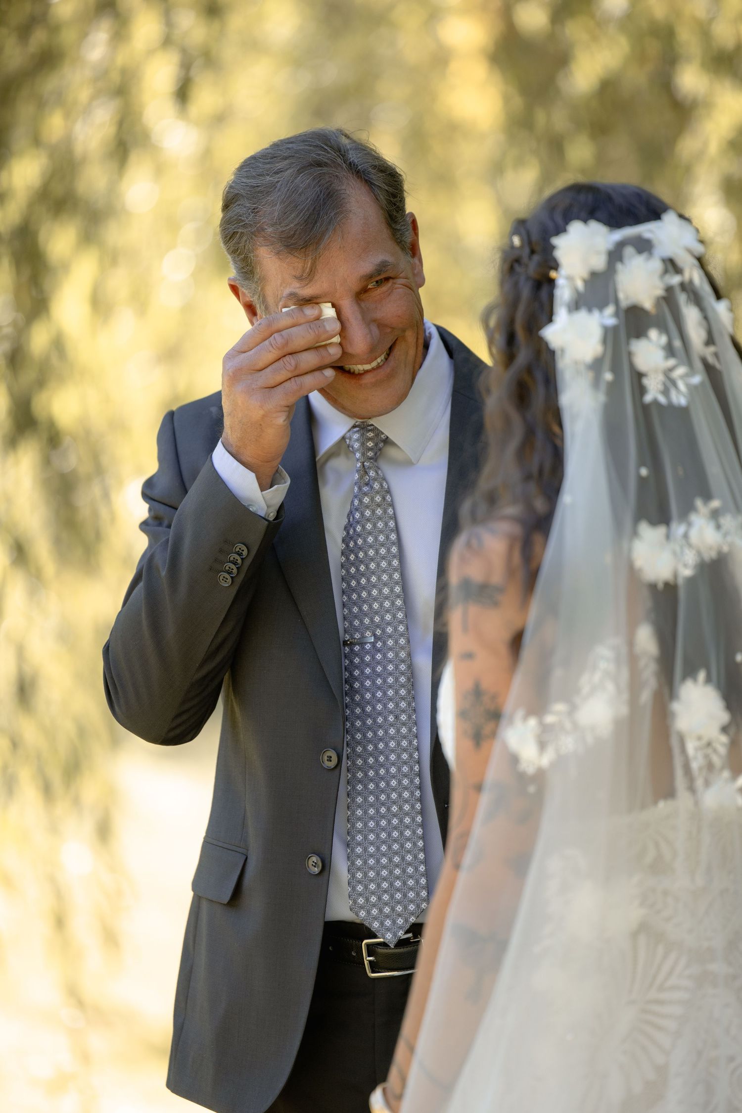 Emotional sequence of father seeing bride in wedding dress for first time in outdoor setting.