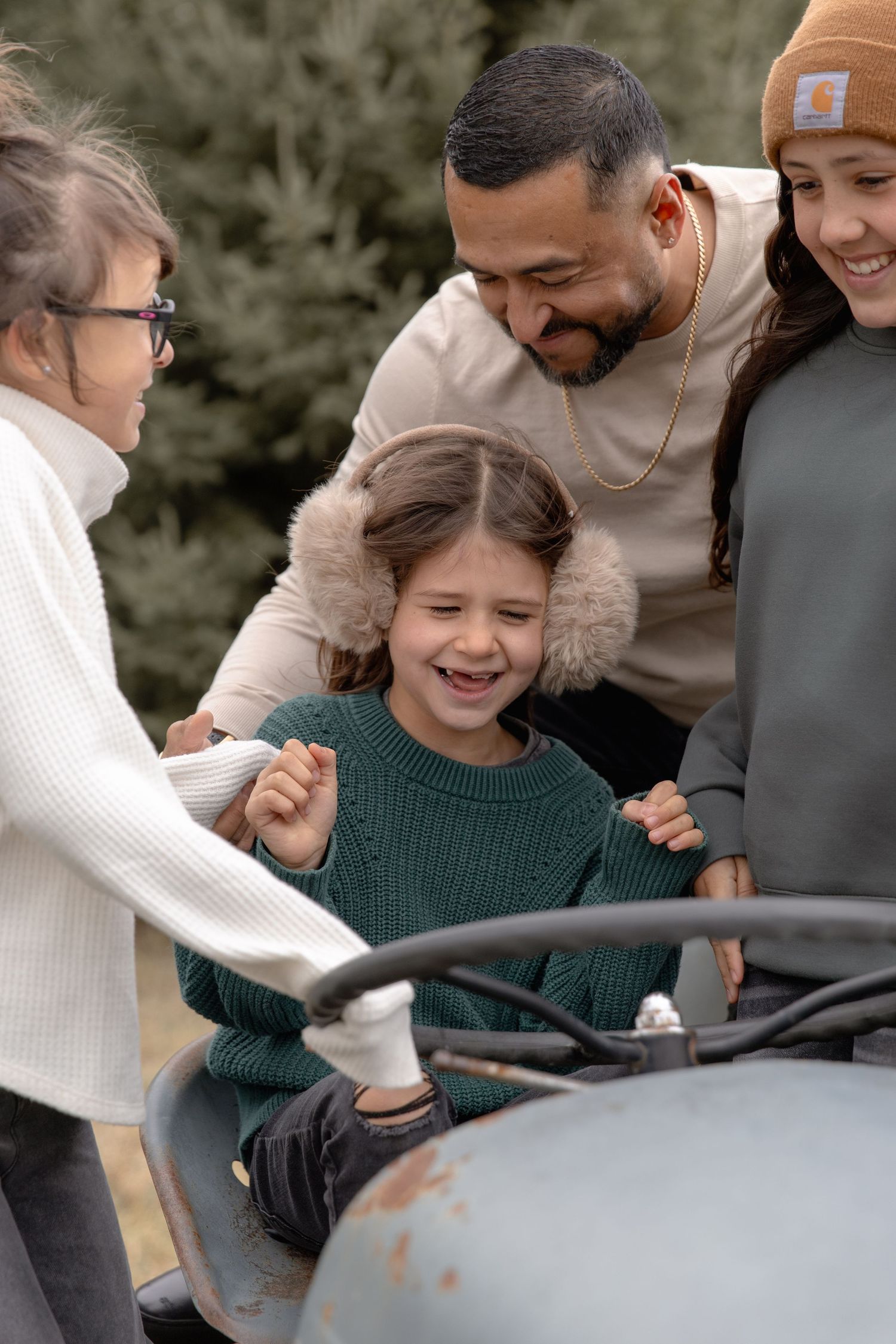 A happy family shares a joyful moment while looking at something together outdoors.