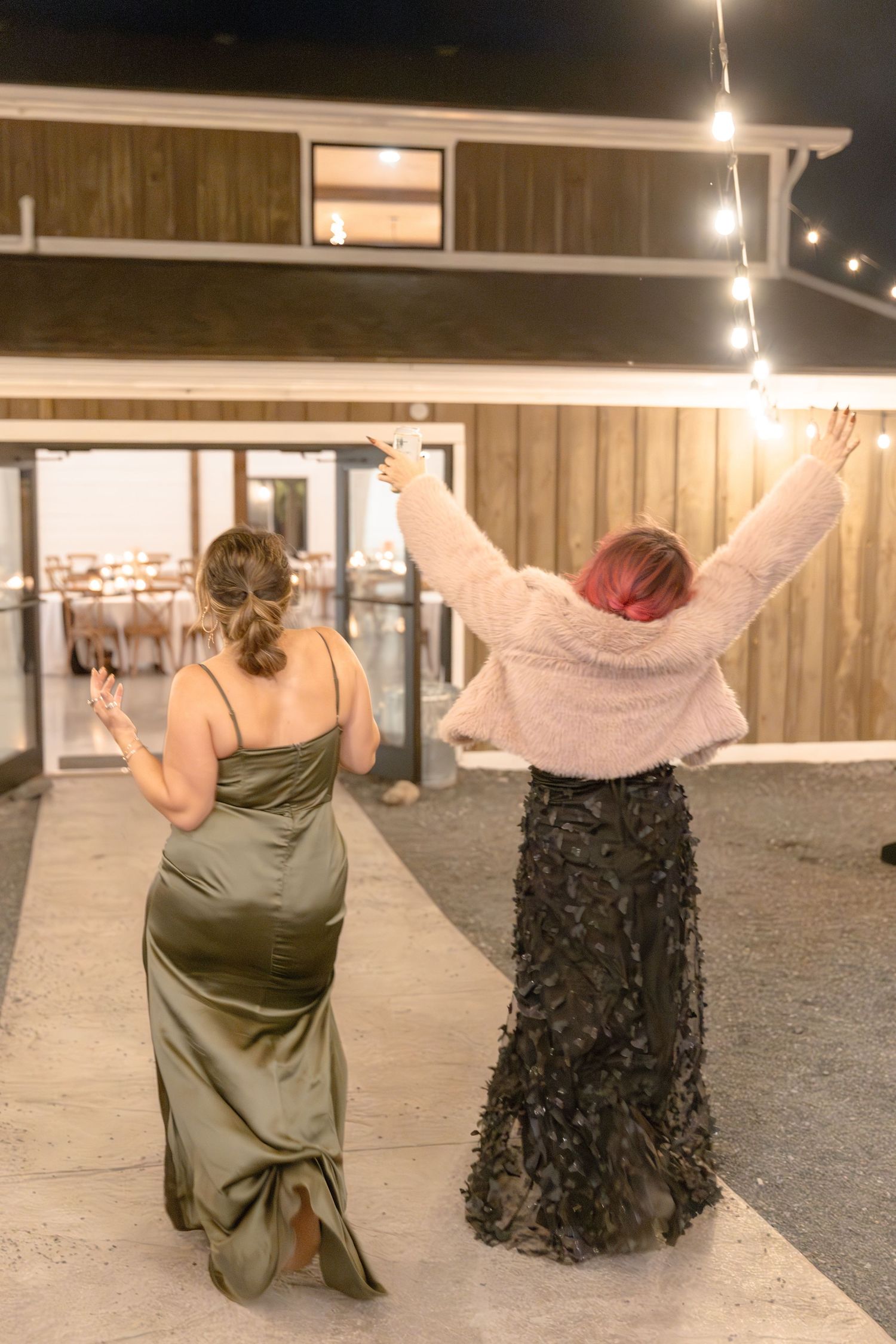 Two dancers perform a contemporary duet under dim lighting in an industrial space with concrete floors.
