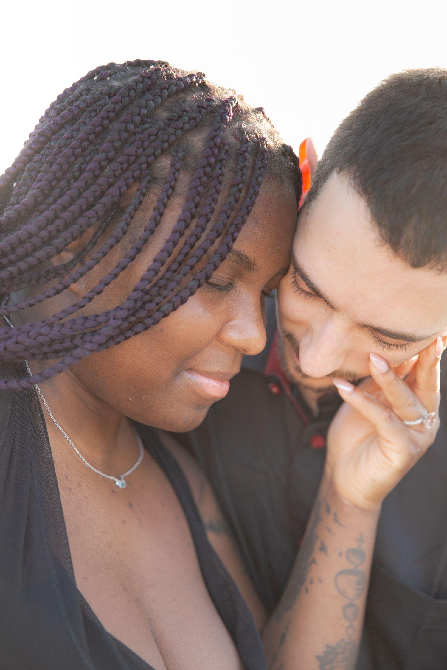 A couple shares an intimate moment together while smiling and embracing.