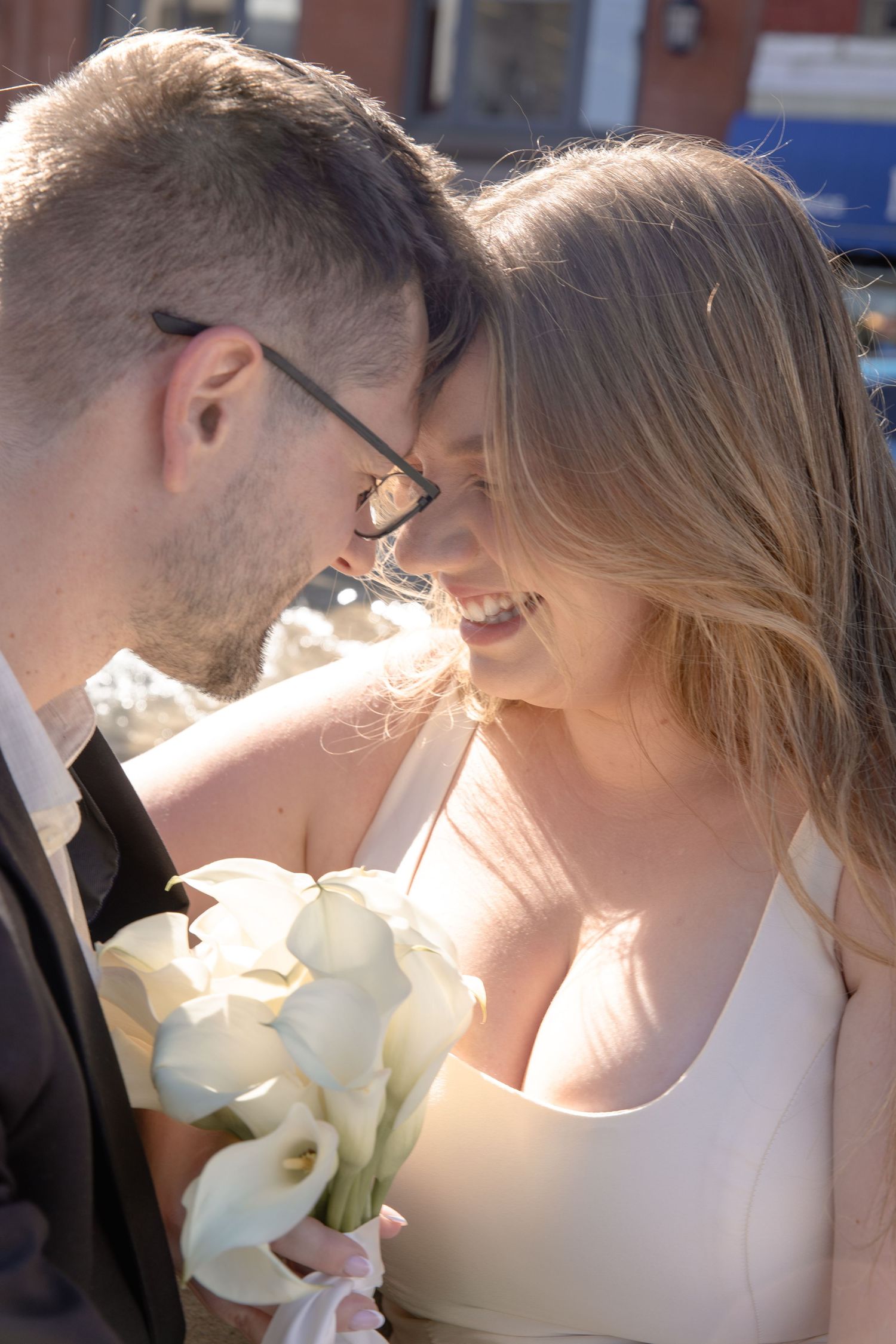 A newlywed couple shares an intimate moment in a series of romantic close-up shots backlit by warm sunlight.