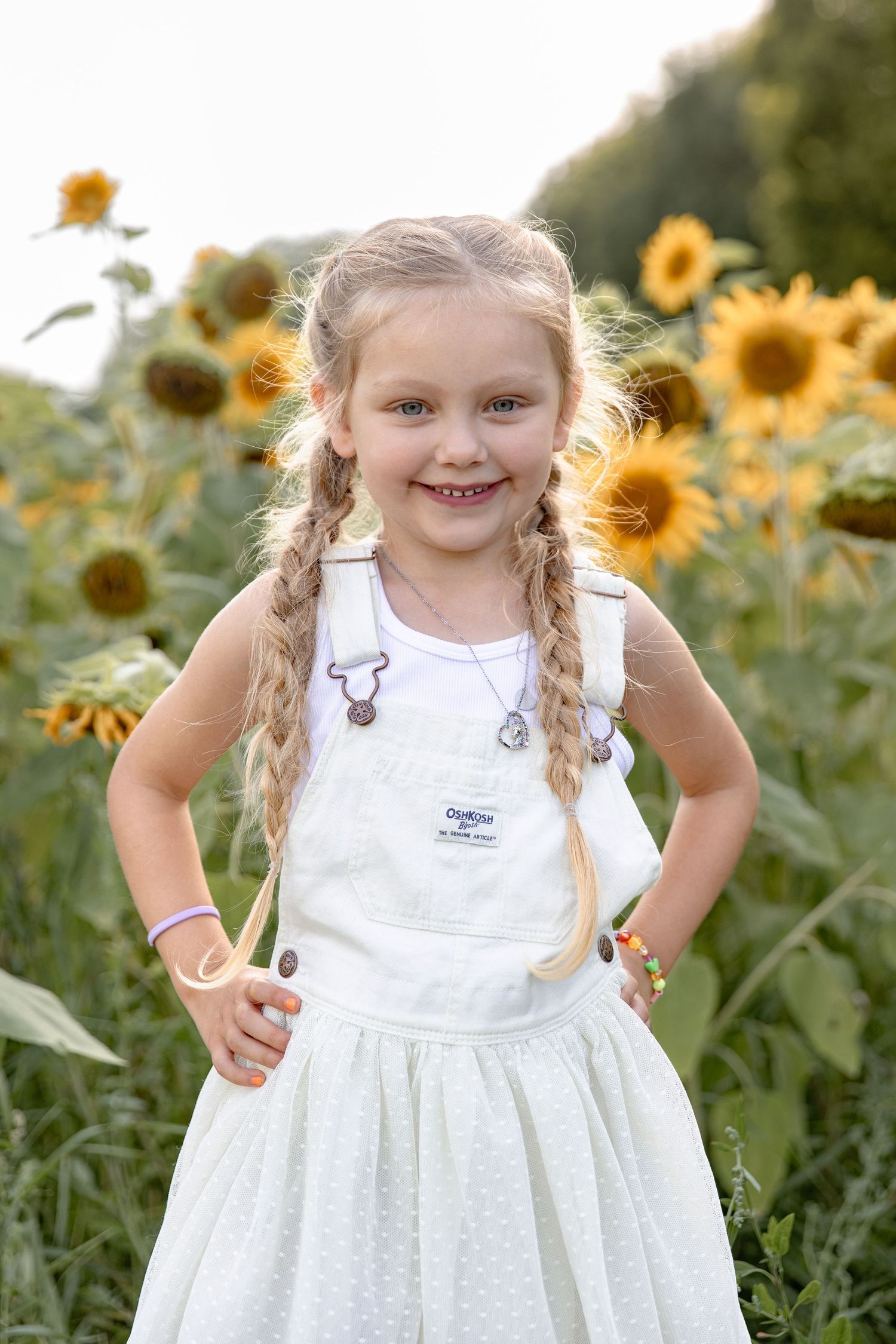 A joyful scene in a sunflower field with someone wearing a white dress and braided hair on a sunny summer day.