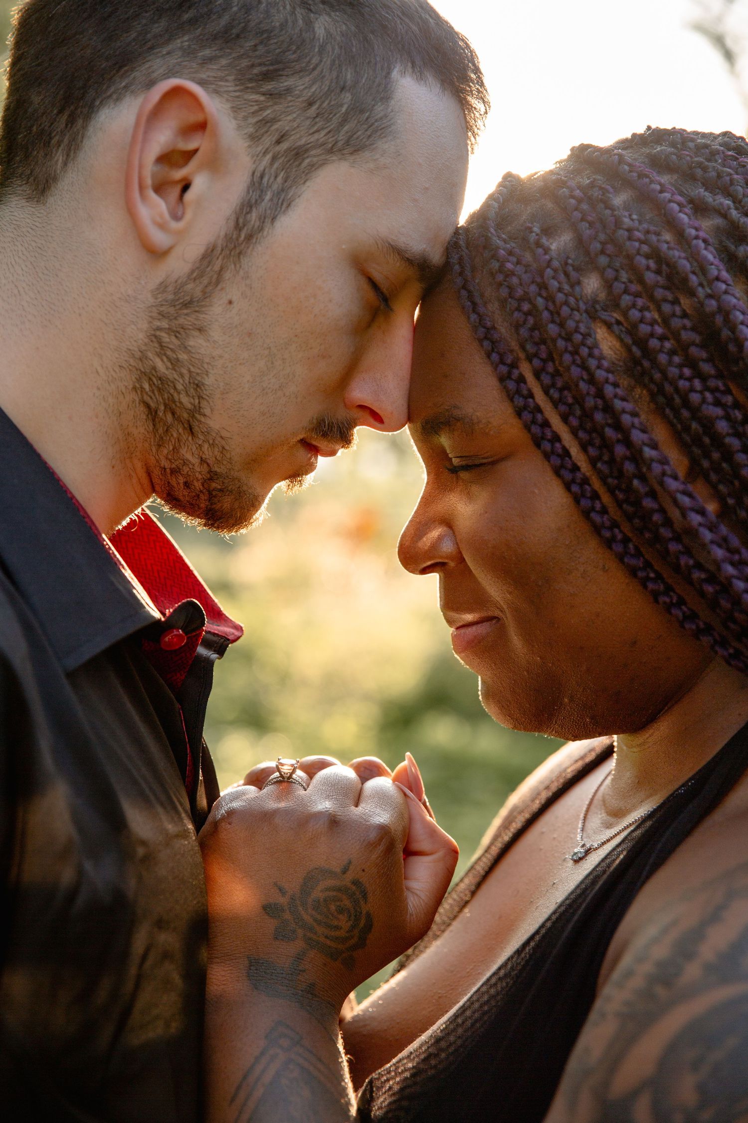 A romantic couple sharing an intimate moment at sunset while holding hands with a soft golden glow in the background.