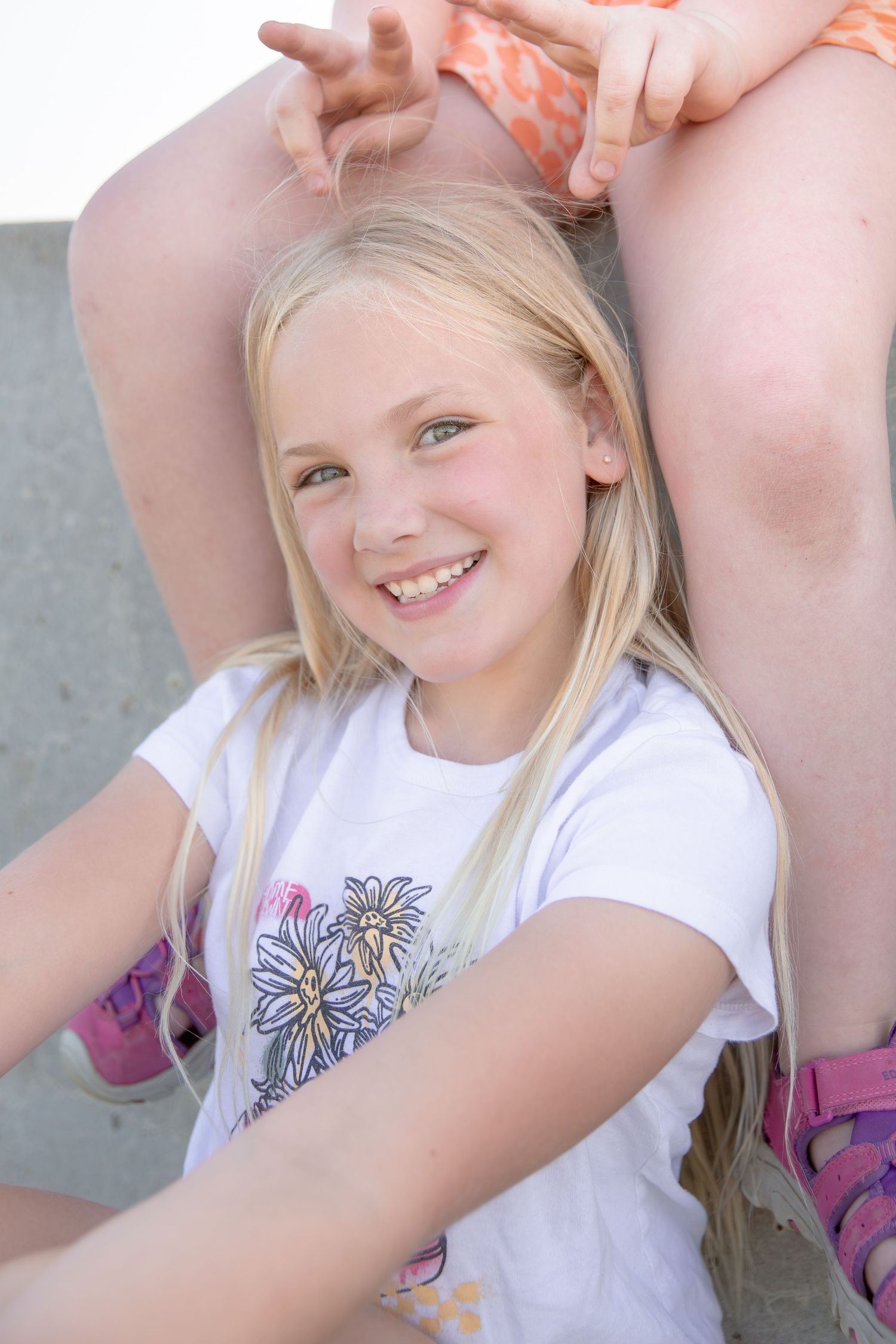 A series of candid outdoor portrait shots showing a person in a white t-shirt with blonde hair and joyful expressions.