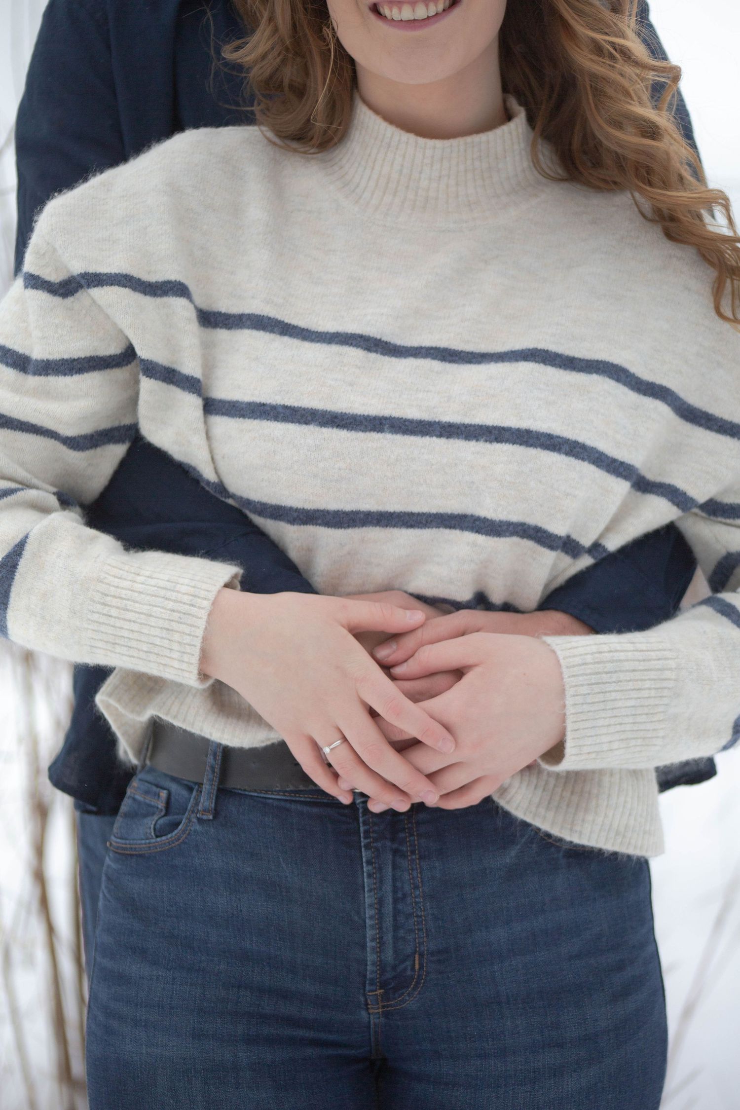Detail shot of hands and a cream striped sweater during an engagement photoshoot.