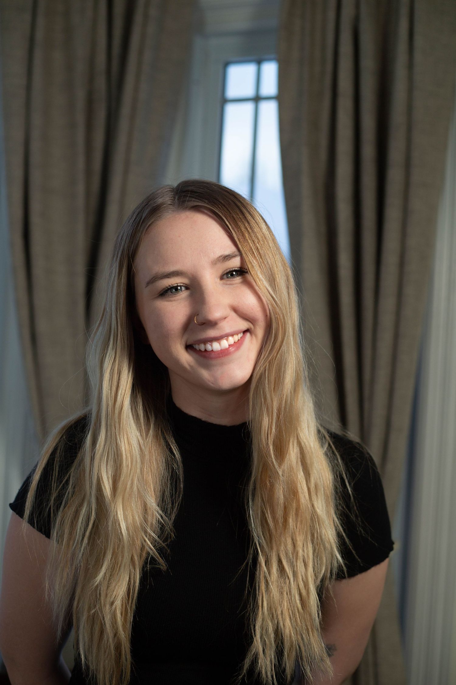 A series of four photos showing someone with blonde hair wearing black, expressing different joyful emotions.