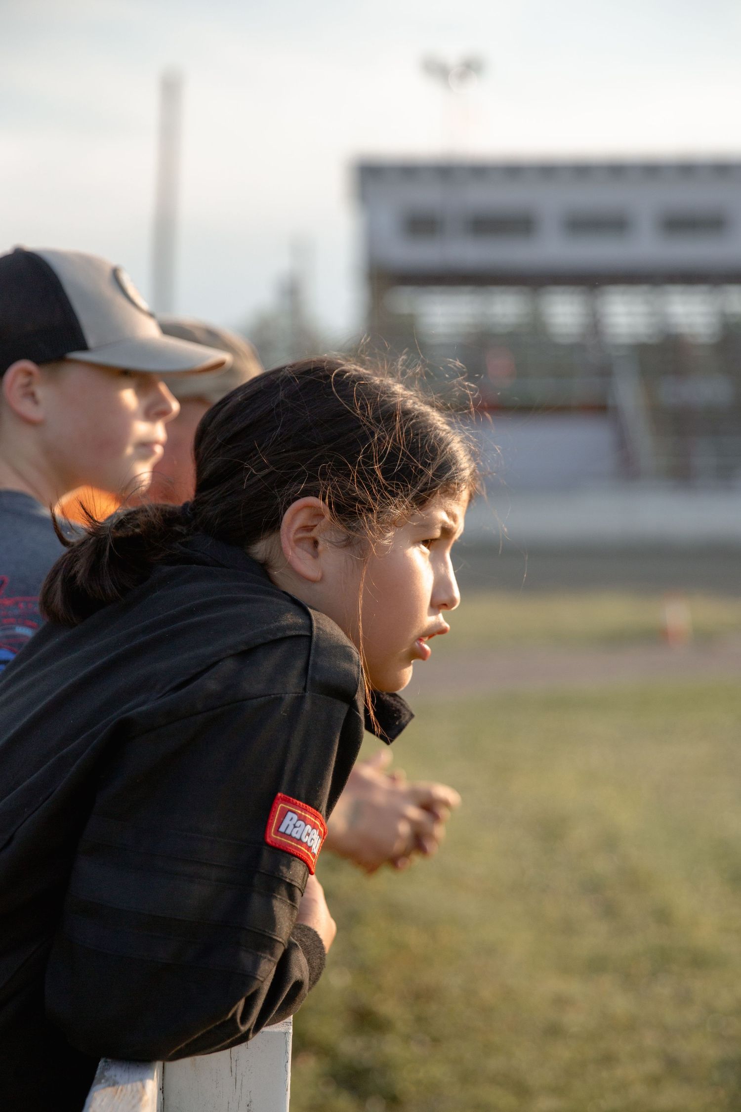 Athletic player in black sports attire makes intense movement during outdoor field practice session.