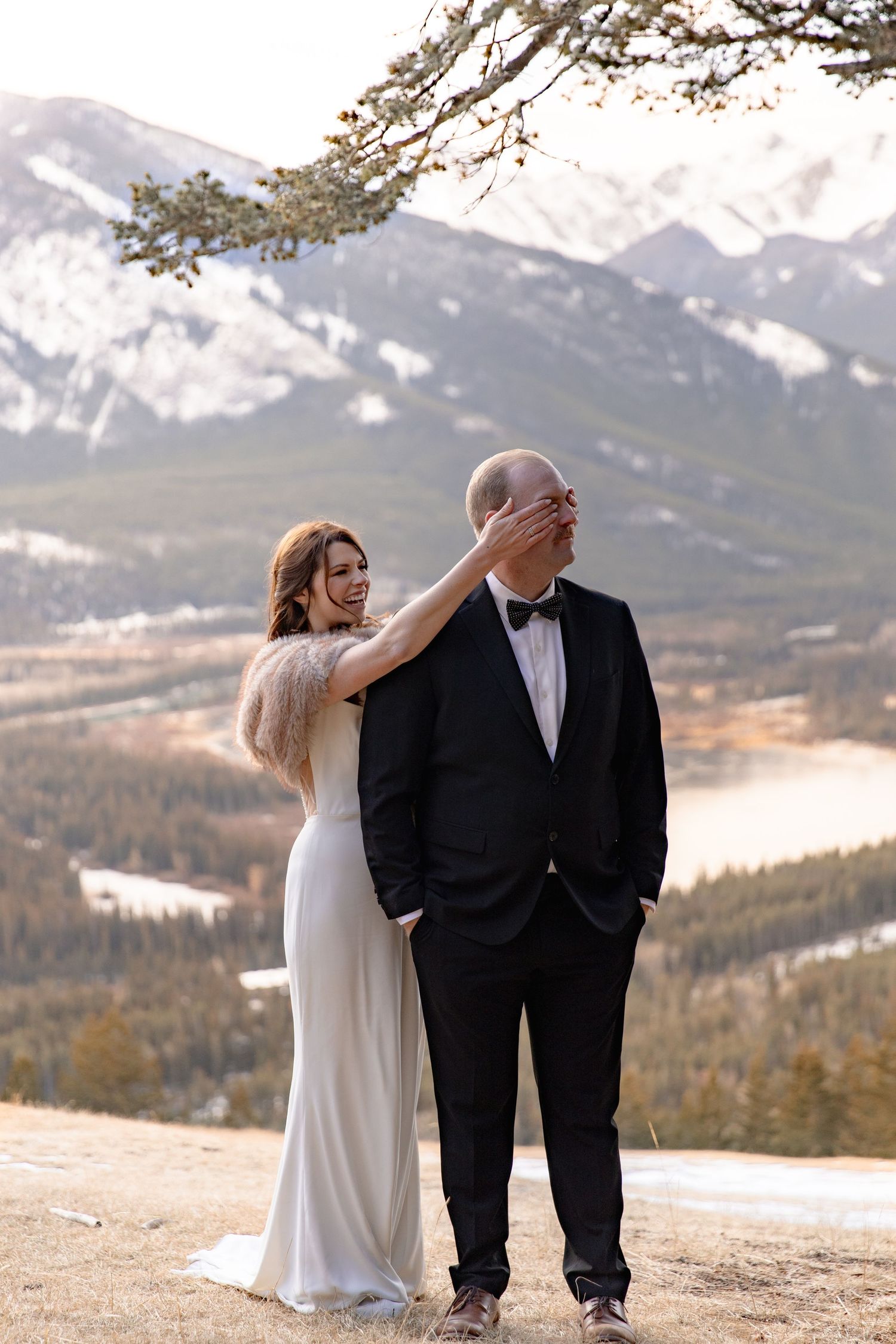 A couple shares intimate moments during their mountain wedding photoshoot with snow-capped peaks in the background.