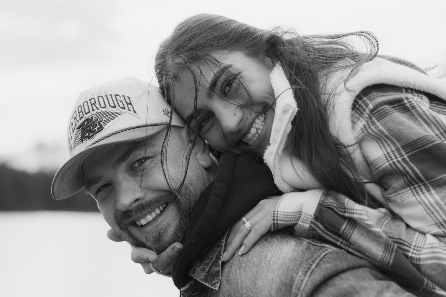 Black and white portrait series showing person in casual attire with natural outdoor backdrop.