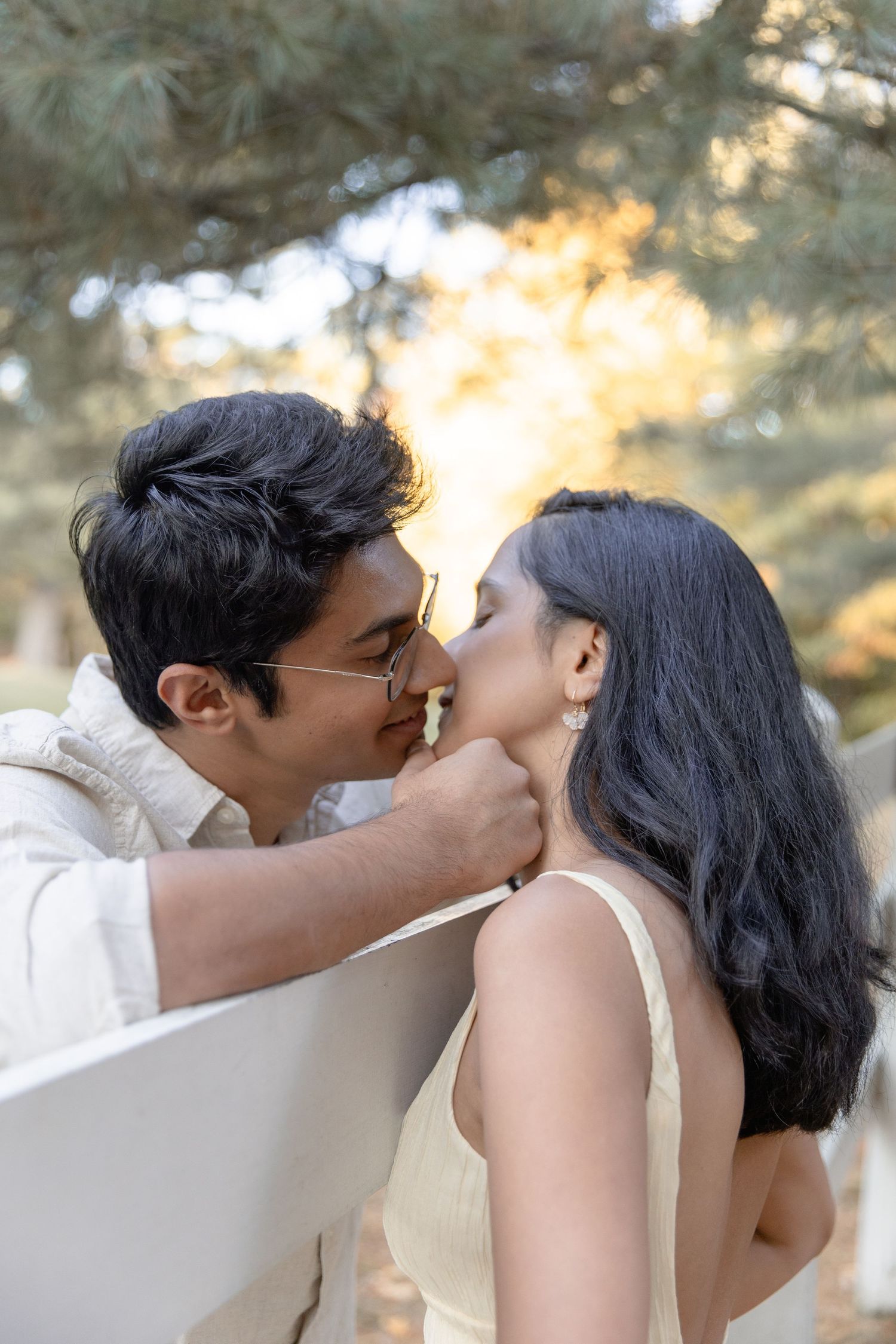 A romantic sequence of four photos showing a couple sharing tender kisses in a sunlit outdoor setting.