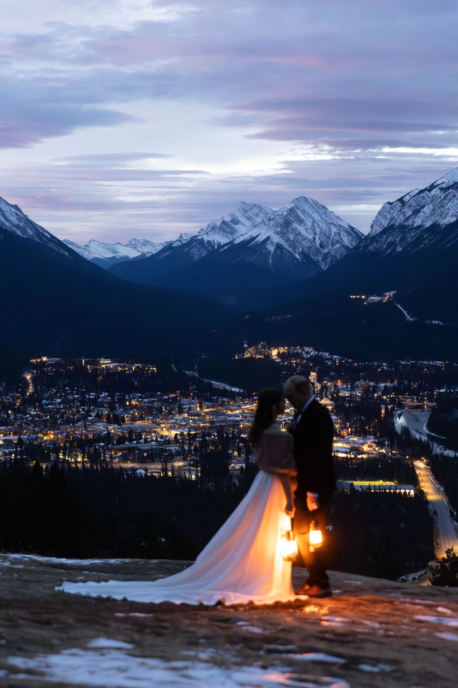 A panoramic timelapse sequence shows a mountain town transitioning from dusk to night with glowing lights in the snow.