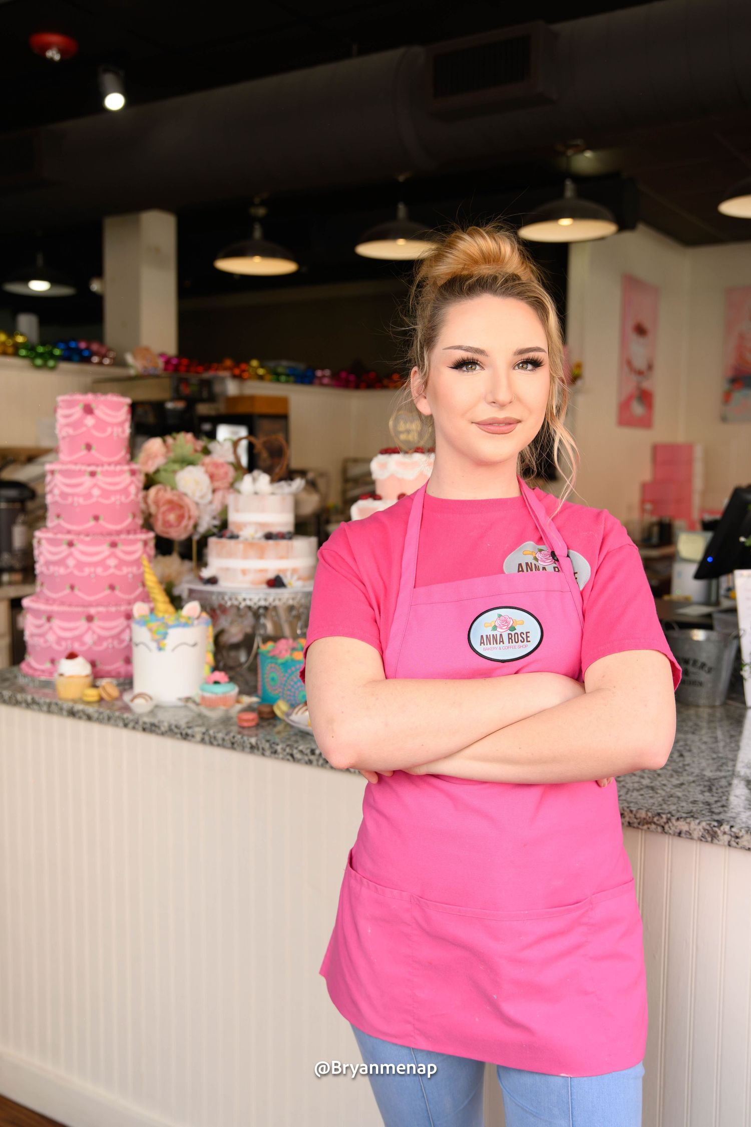 Pink bakery interior with tiered cakes displayed on white counters and pink decor visible in the background.