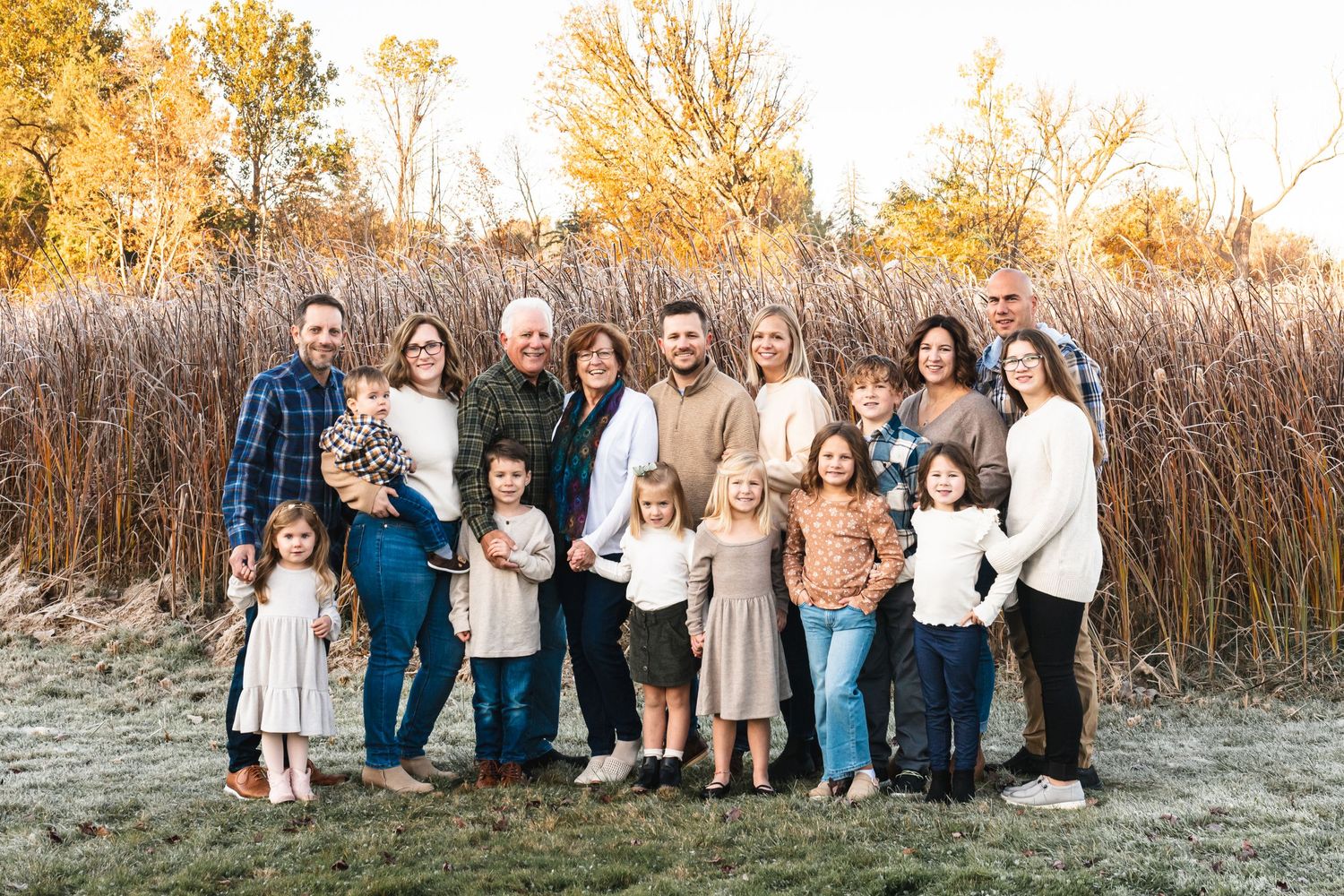 Three-generation family photo in a fall field at sunrise.