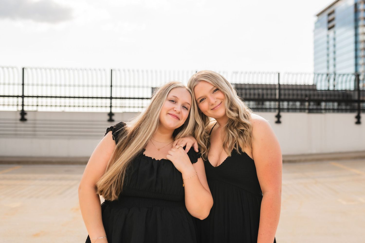 A portrait of 2 best friends senior girls on a roof in Grand Rapids during their senior photos.
