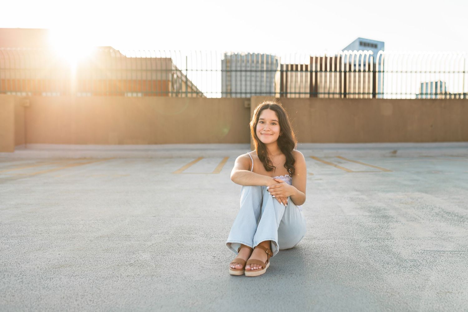 Portrait of a senior girl on a rooftop in Grand Rapids, MI with the skyline behind her.