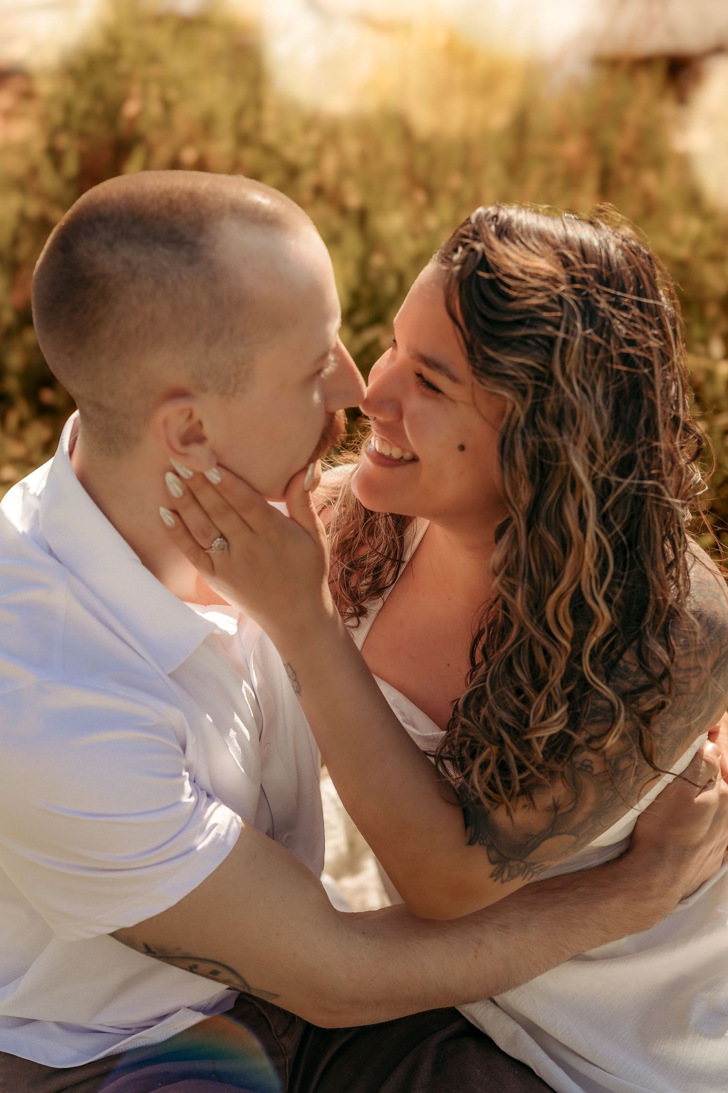 A tender moment between parent and child captured in warm sunlight during an outdoor photo session.