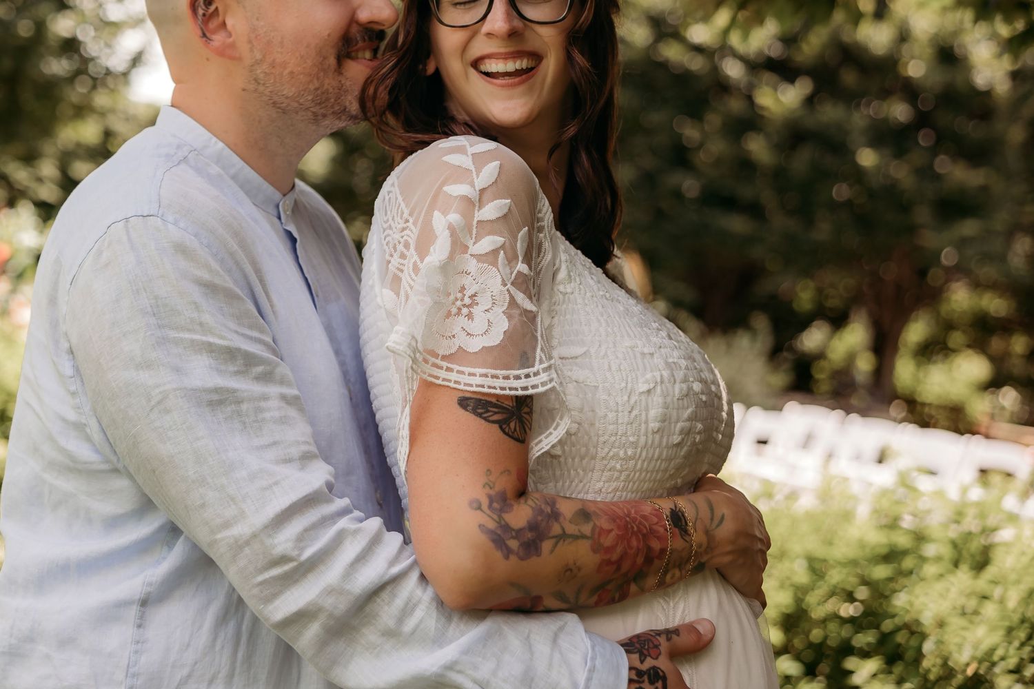 A wedding couple embraces in a sunlit garden setting with romantic natural lighting and soft bokeh effects.