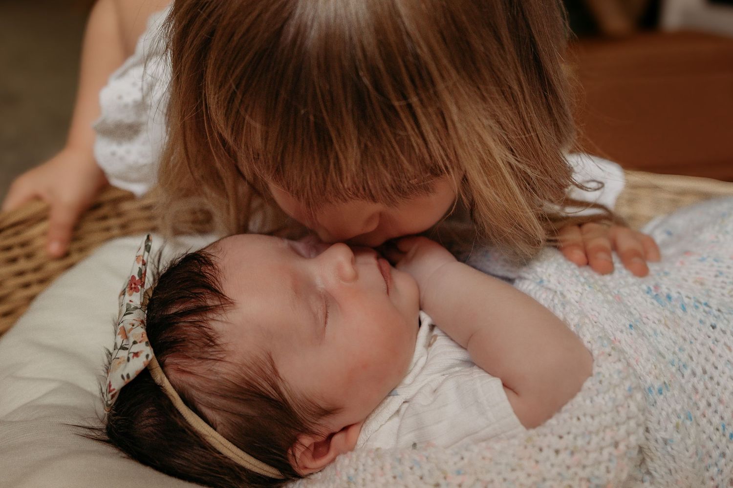 Tender moment shared in intimate close up on white blanket.