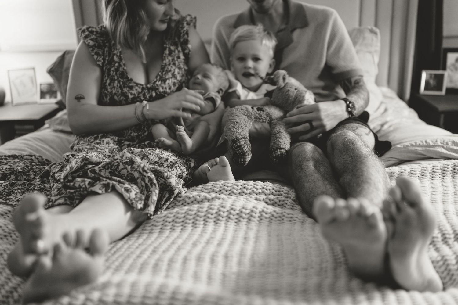 Five black and white images of laid back moments on a checkered bed sheet blend together in a horizontal timeline.