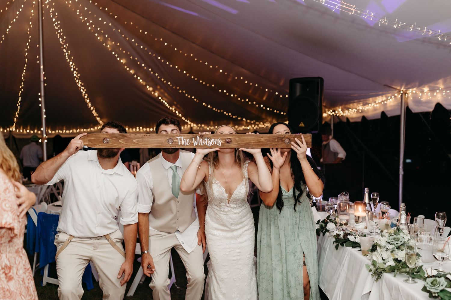 Wedding reception venue decorated with string lights and white floral arrangements for a romantic evening celebration.