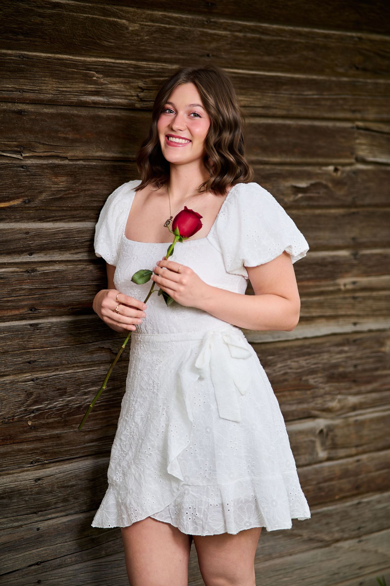 Rustic Senior Session portrait located in South Jordan, UT. White Dress, Red rose.