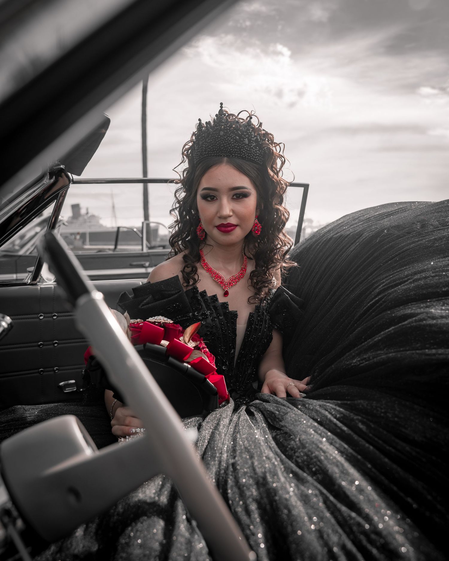 Artistic shots of a person in a black ballgown posing near a vintage car.