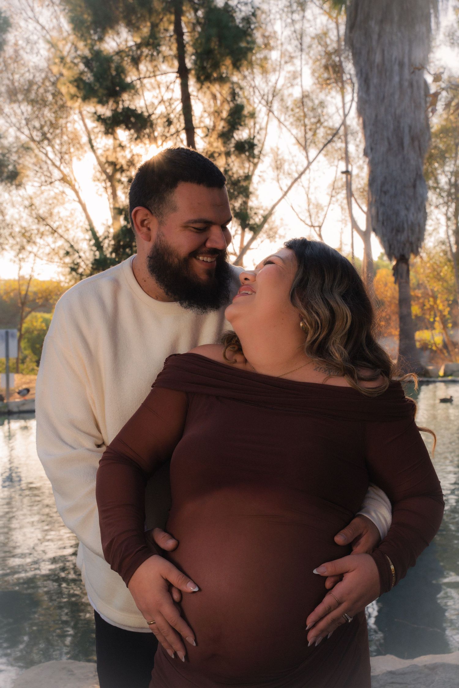 Intimate maternity photos of a couple sharing tender moments in a natural outdoor setting.