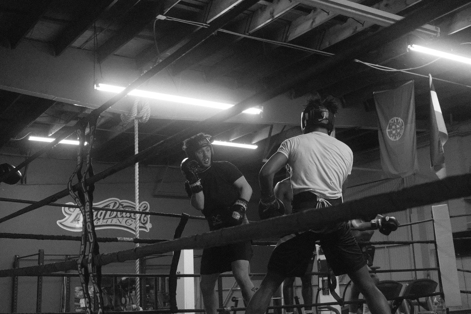 Athletes performing high-intensity training exercises in a dimly lit gym.