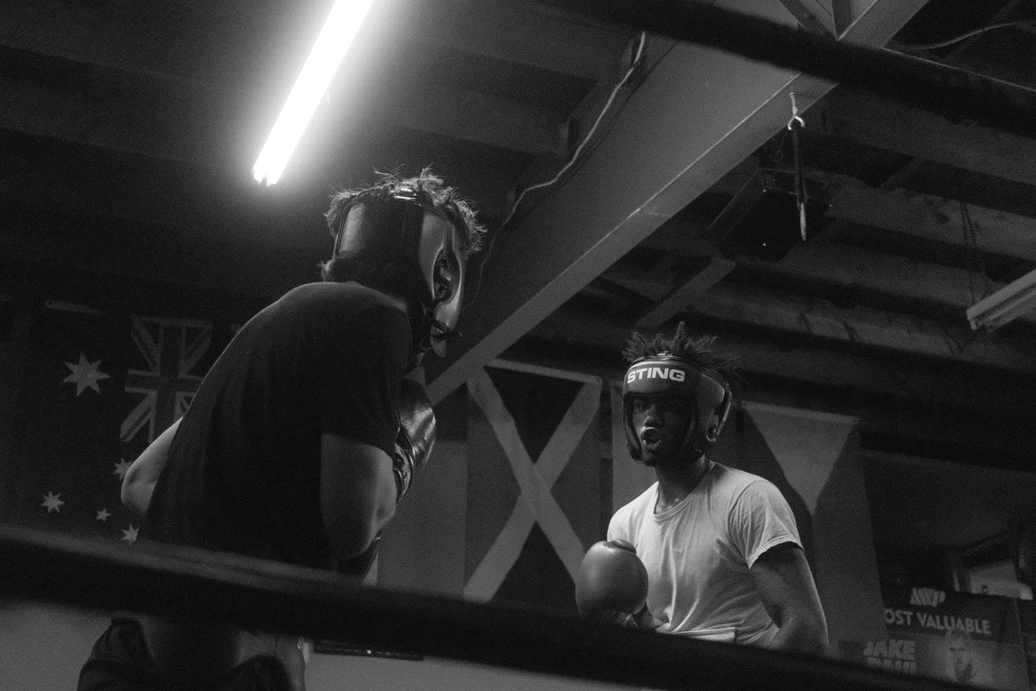 Silhouetted figures working out in an industrial-style fitness facility.