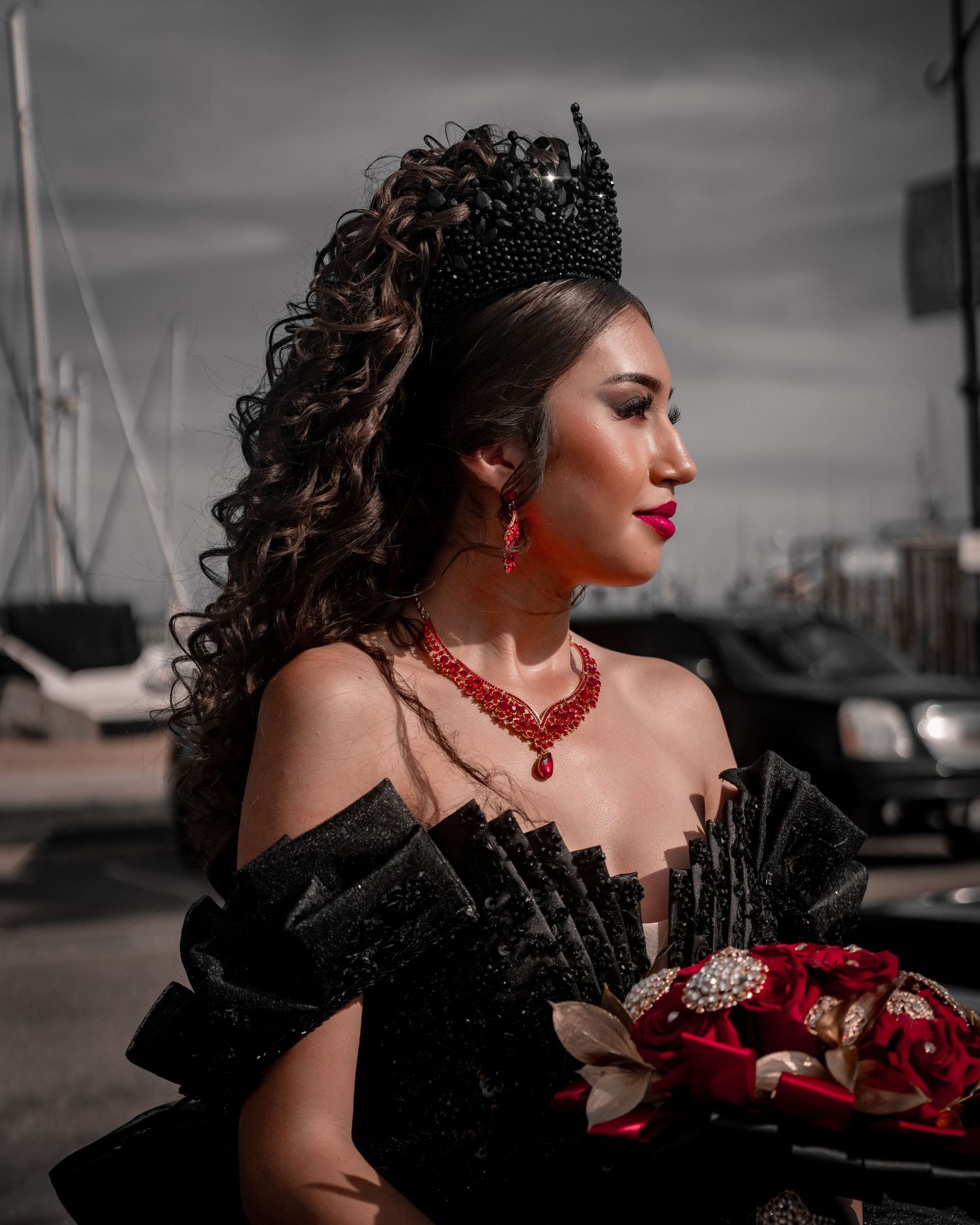 Dramatic fashion portraits with red roses against industrial backdrop.