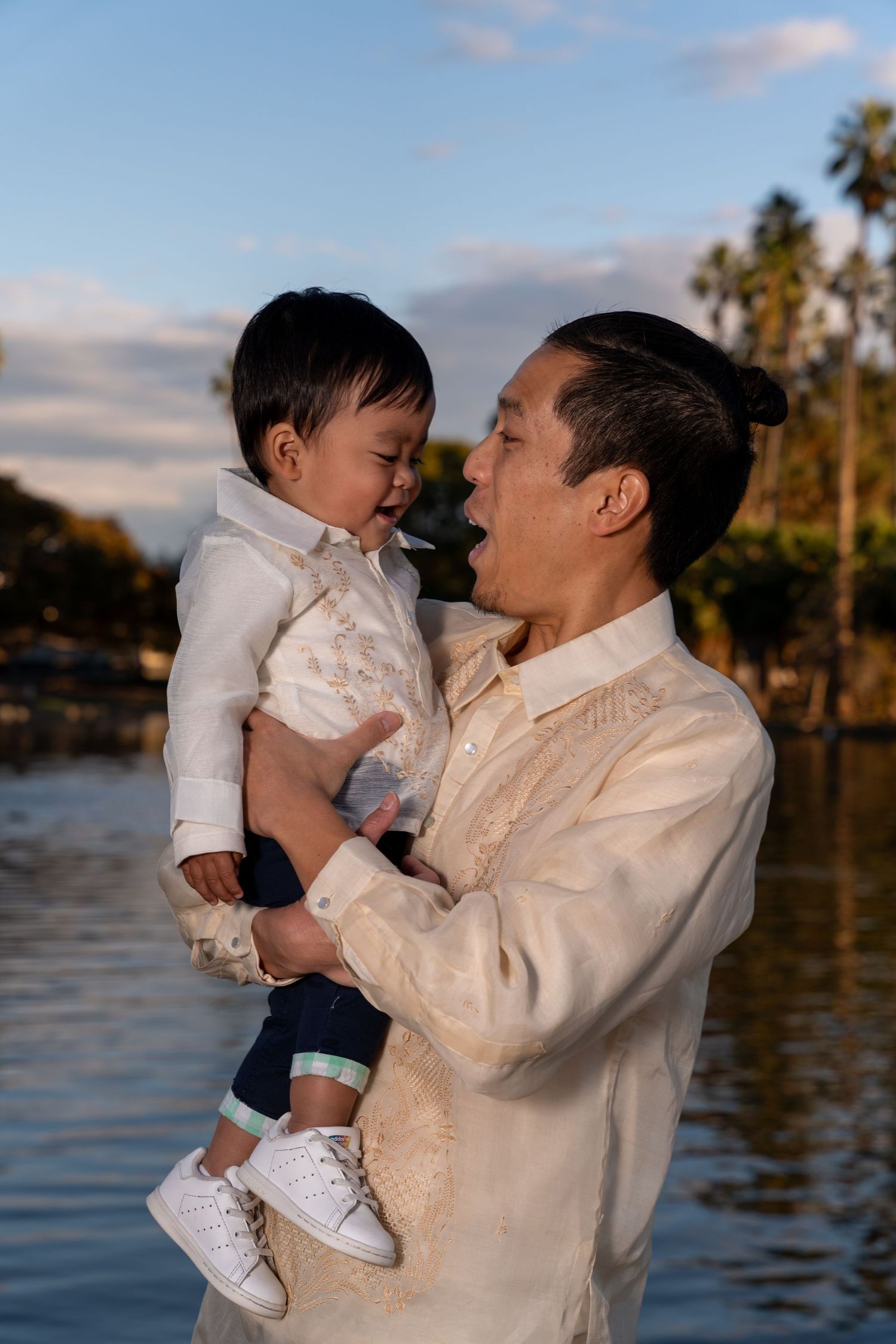 Candid family moments captured at sunset by a waterfront with palm trees.