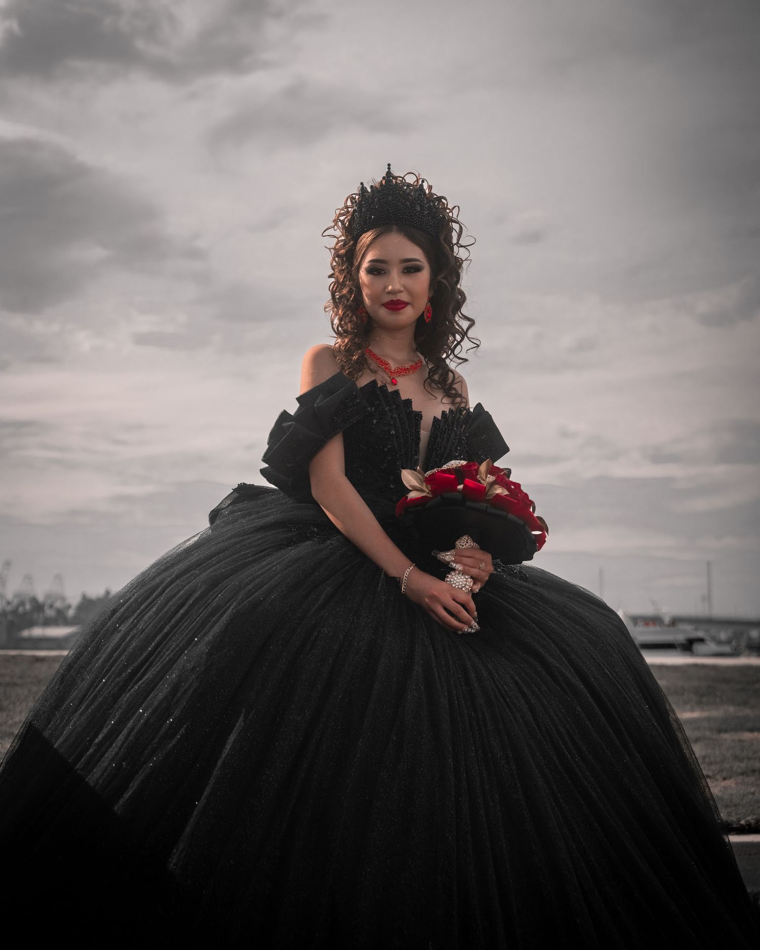 Moody portraits of a person in a black ballgown with red floral accents.
