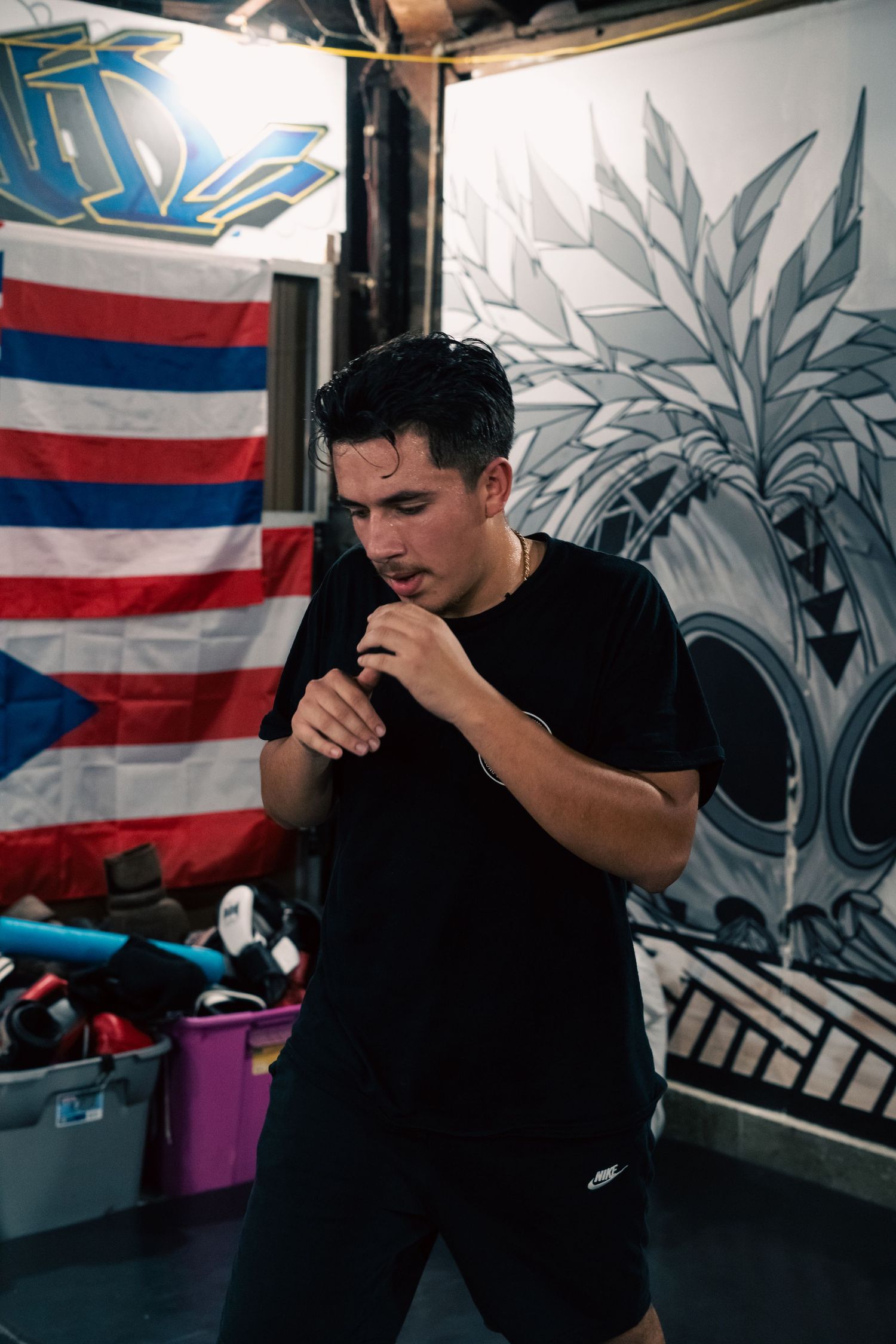 Boxing training session in front of an American flag and wall art.