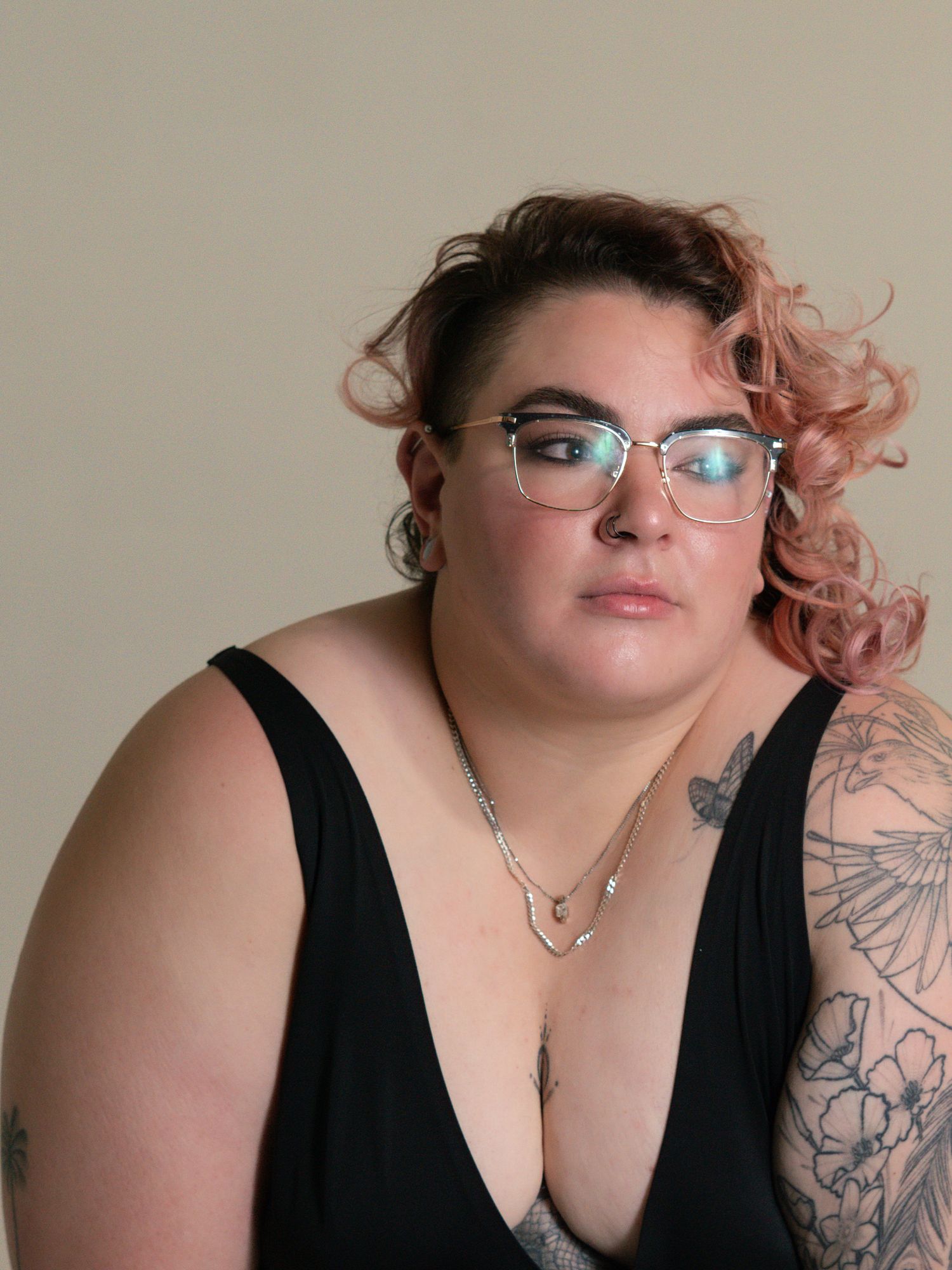 Boudoir portraits featuring a person in black with glasses and tattoos.
