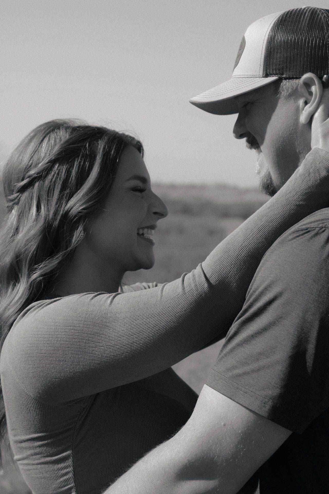 A romantic black and white portrait showing an intimate moment outdoors.