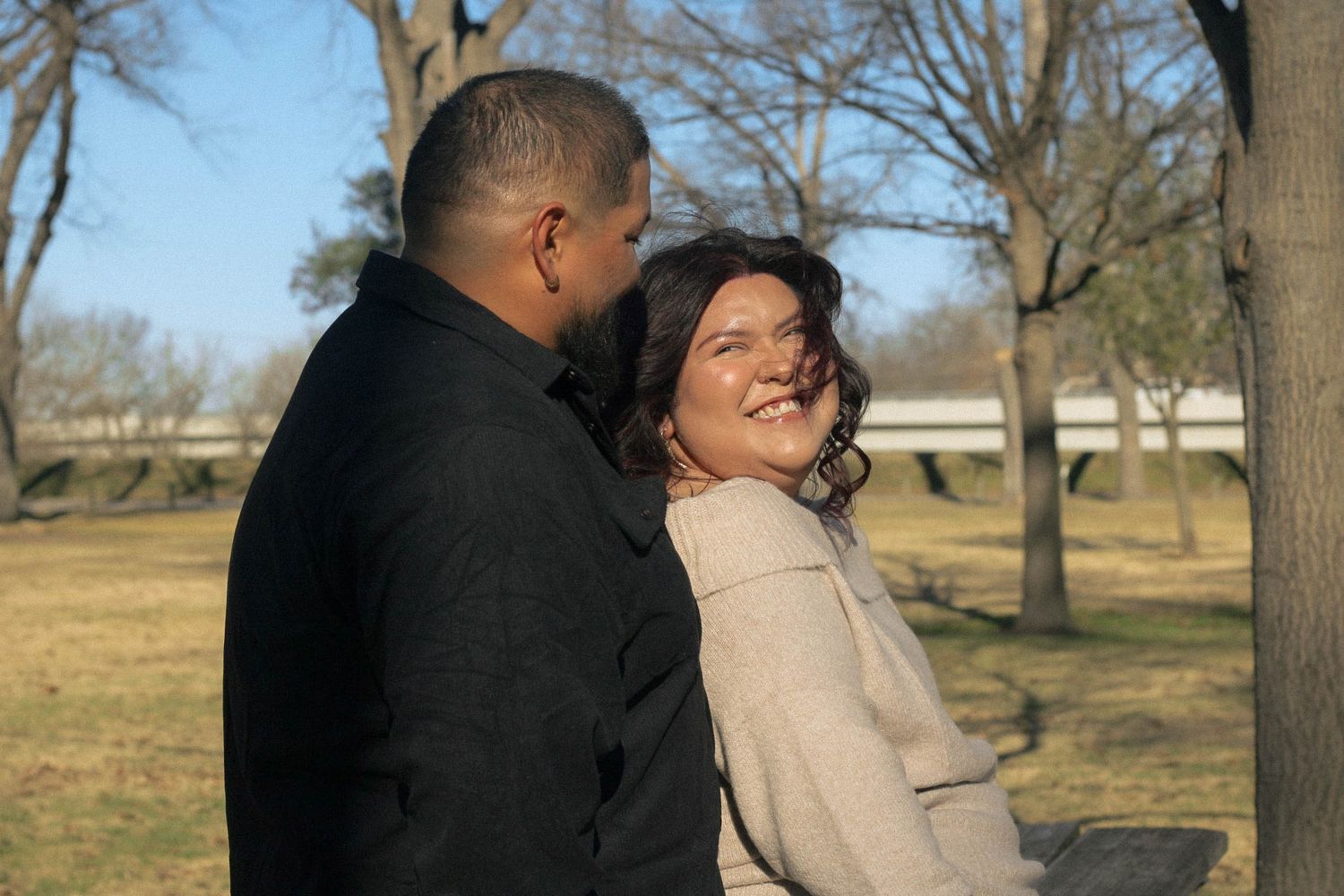 A loving couple shares laughter during their outdoor photo session.