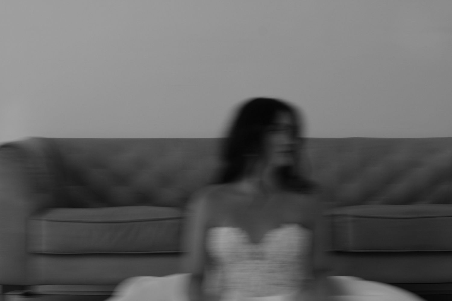 Dark silhouettes on a couch in a minimalist monochrome setting.
