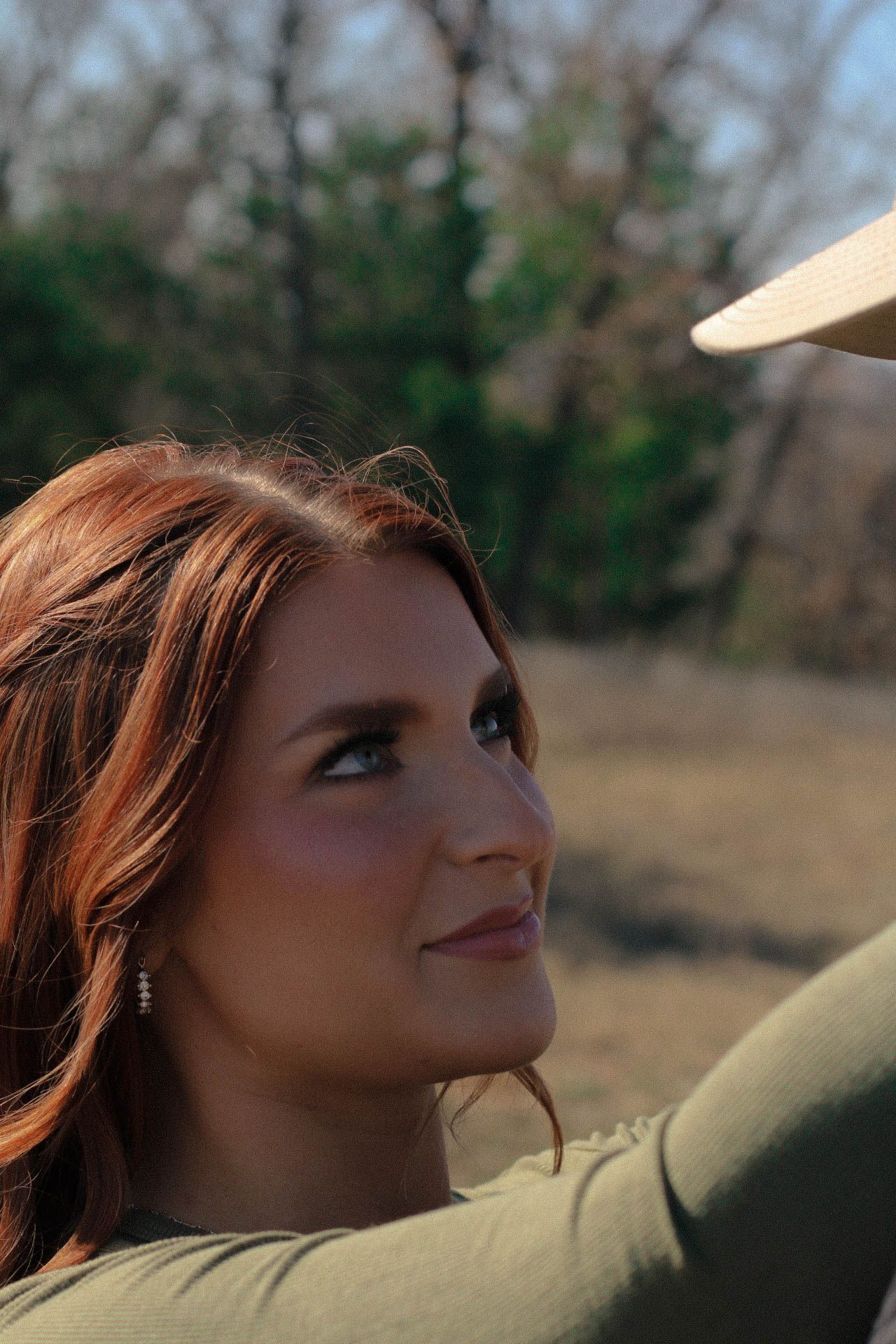 A close-up profile shot against a natural outdoor backdrop.