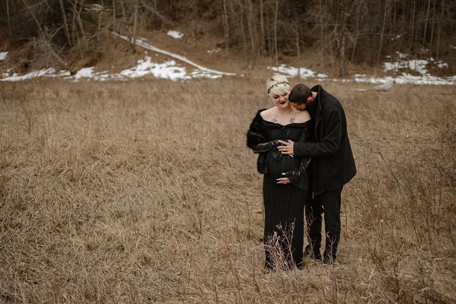 Pregnant mom being kissed on the shoulder by dad for maternity photos in Calgary