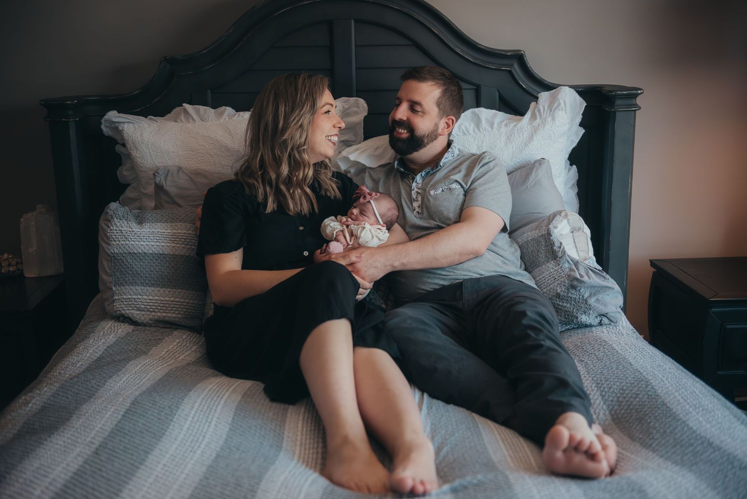 Candid family moment captured on bed during lifestyle newborn session.