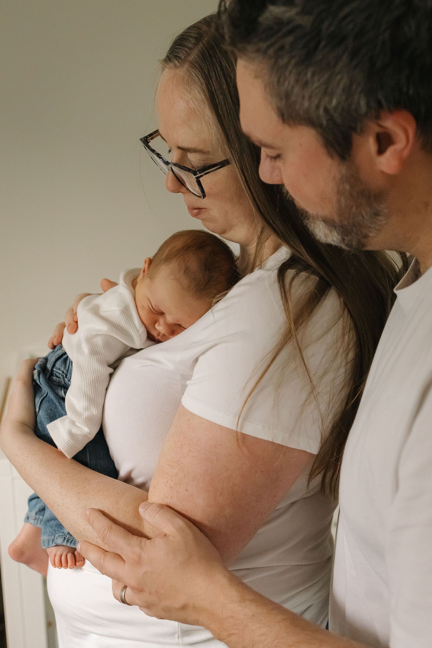 Mom and dad snuggling with their newborn baby