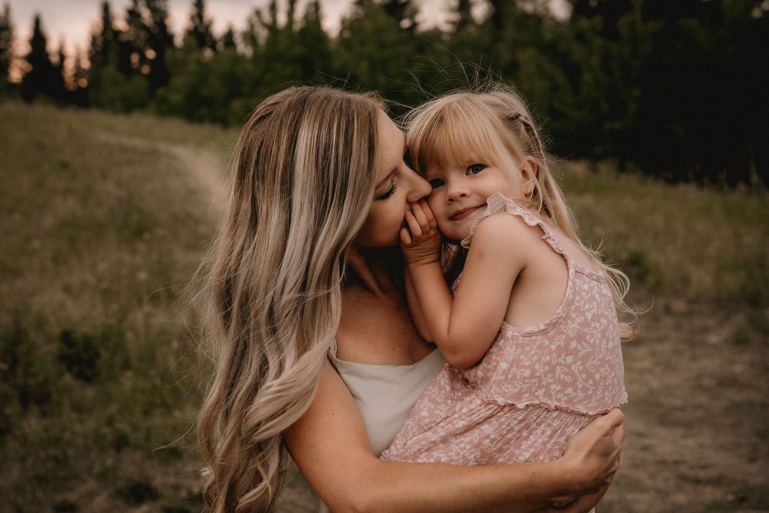 A tender outdoor family moment captured at Shannon Terrace, AB at sunset with soft golden lighting by Calgary lifestyle photographer