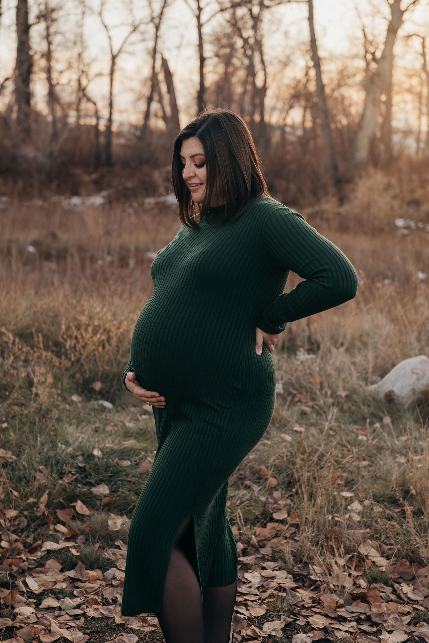 A maternity photo shoot in Calgary, AB with fallen autumn leaves.